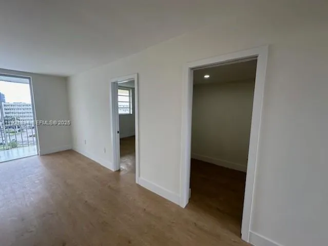 an empty room with windows and closet