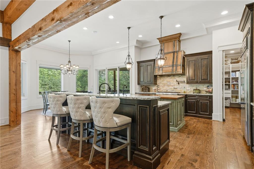 680 Gaddis Road Canton, GA 30115 - Photo 13 of 85 a kitchen with stainless steel appliances granite countertop a table chairs stove and wooden floor