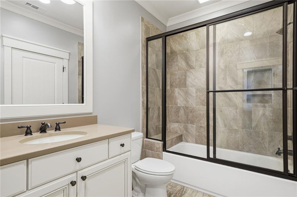 680 Gaddis Road Canton, GA 30115 - Photo 39 of 85 a bathroom with a sink a mirror a toilet and a glass door shower