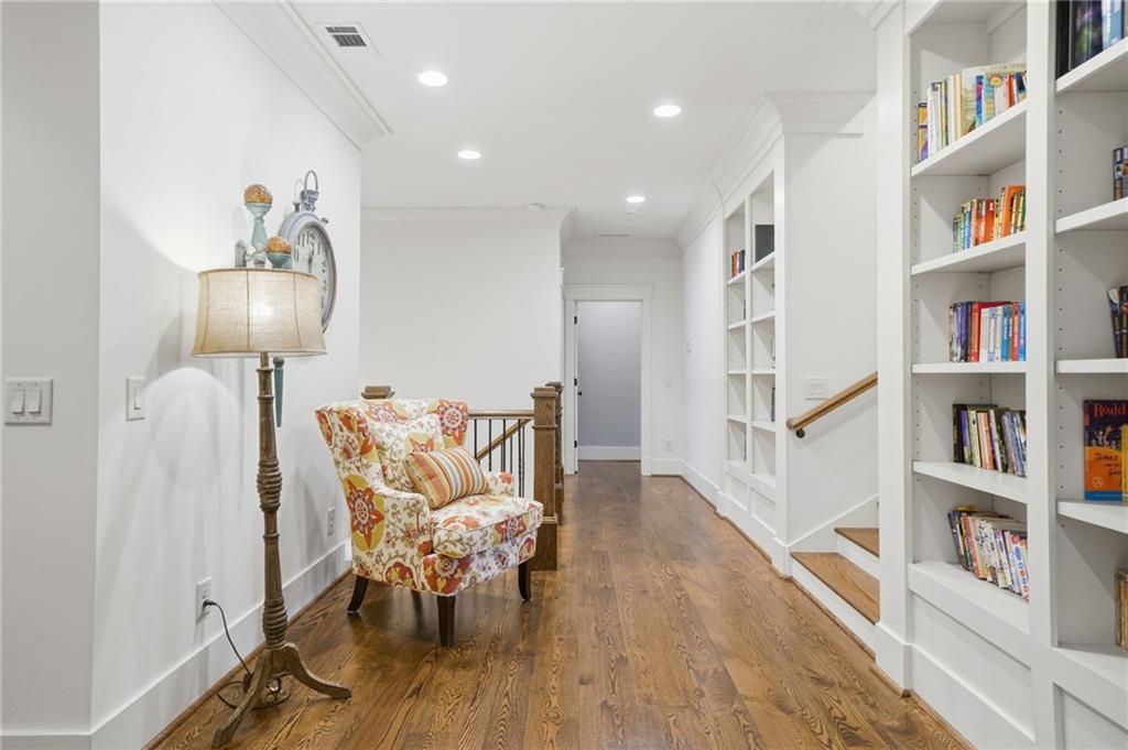 680 Gaddis Road Canton, GA 30115 - Photo 48 of 85 a hallway with a book shelf and a wooden floor