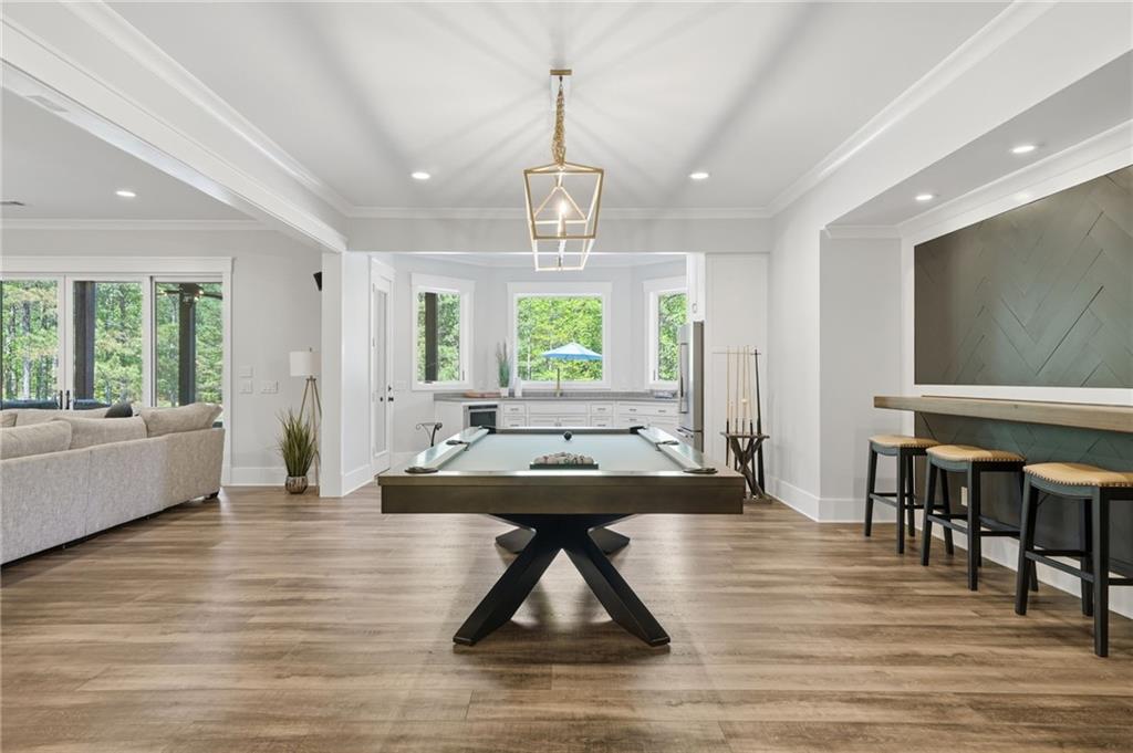 680 Gaddis Road Canton, GA 30115 - Photo 52 of 85 a dining room with wooden floor a chandelier a wooden table and chairs
