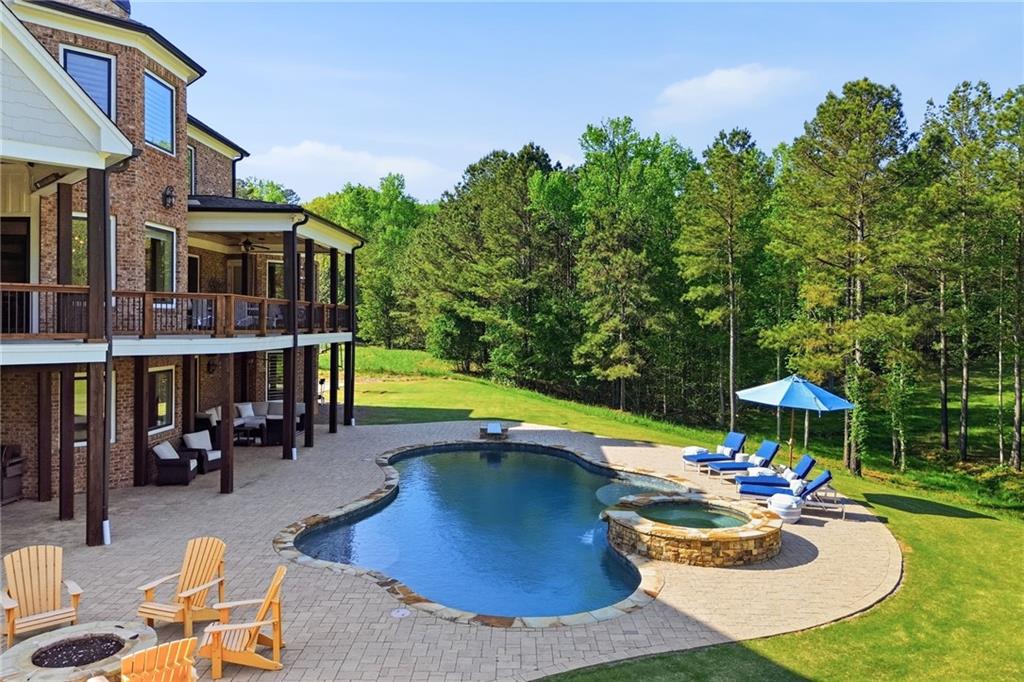 680 Gaddis Road Canton, GA 30115 - Photo 74 of 85 a view of a swimming pool with a table and chairs under an umbrella
