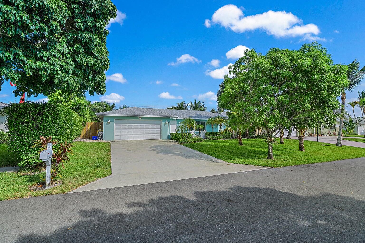 356 Mars Avenue Tequesta, FL 33469 - Photo 24 of 25 a view of a house with a yard and large tree