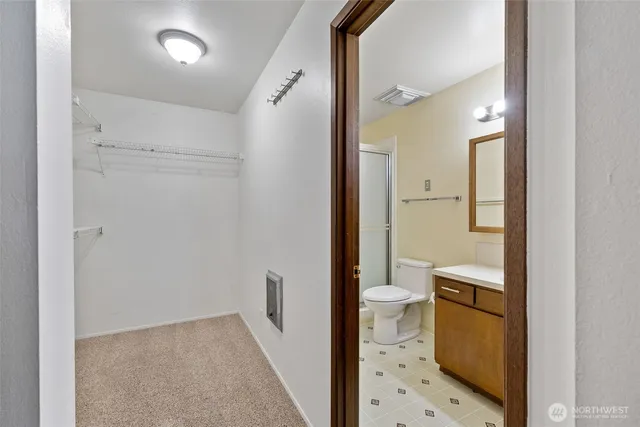 a bathroom with a sink a toilet a mirror and shower