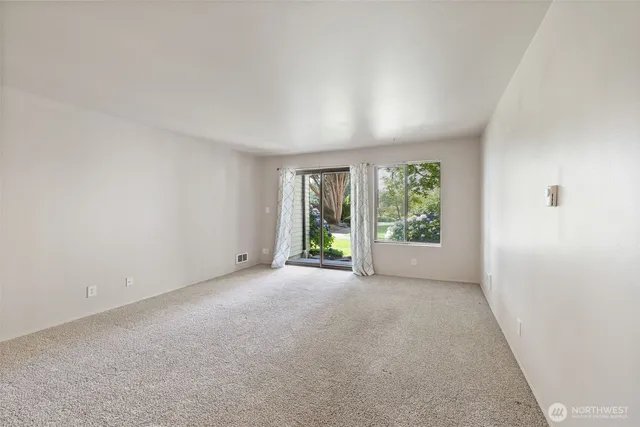 a view of a big room with windows and chandelier fan