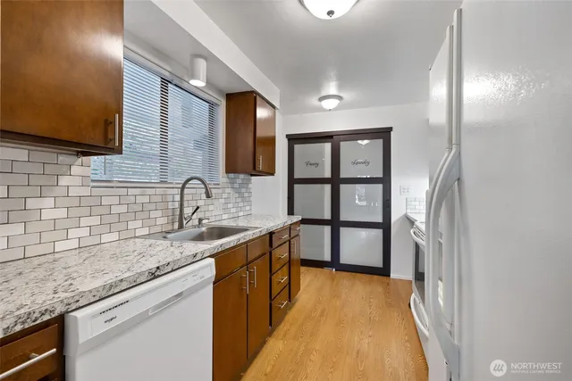 a kitchen with stainless steel appliances granite countertop a sink and wooden cabinets