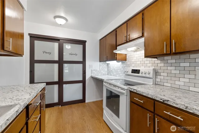 a kitchen with granite countertop wooden cabinets and white appliances