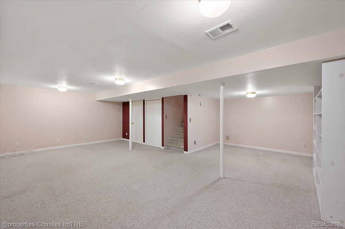 955 Rikki Ann Court Wixom, MI 48393 - Photo 51 of 54 Finished basement featuring stairway and light carpet
