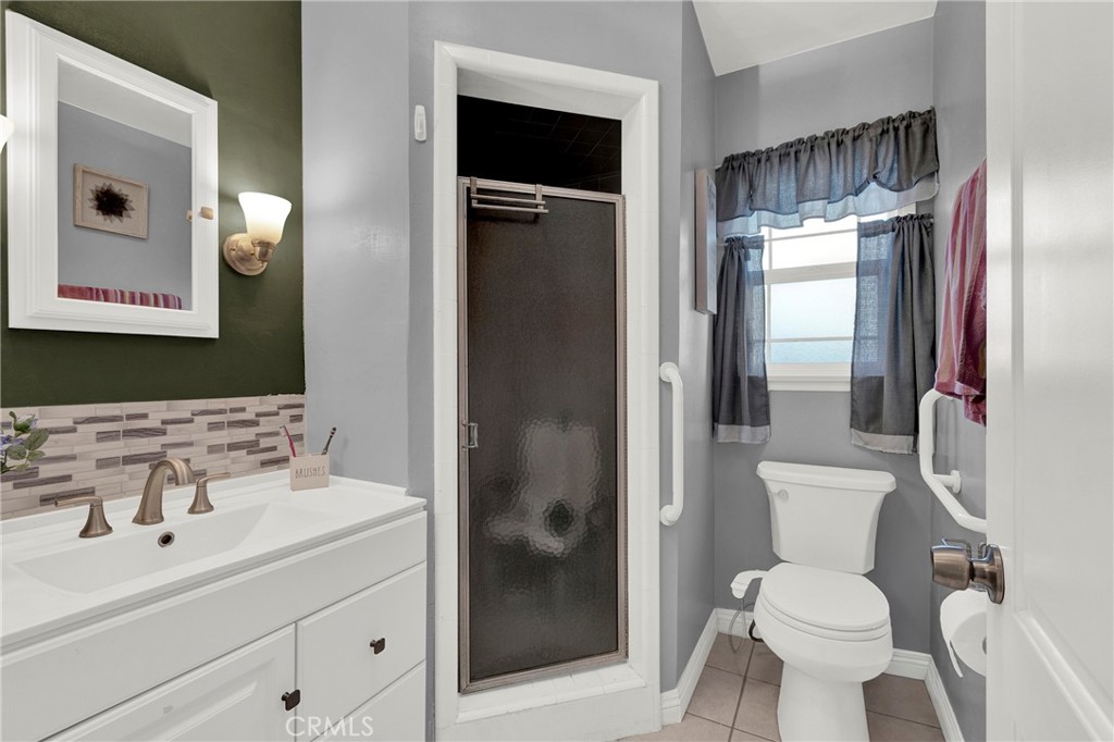 133 East Van Koevering Street Rialto, CA 92376 - Photo 13 of 23 a bathroom with a toilet sink shower and mirror