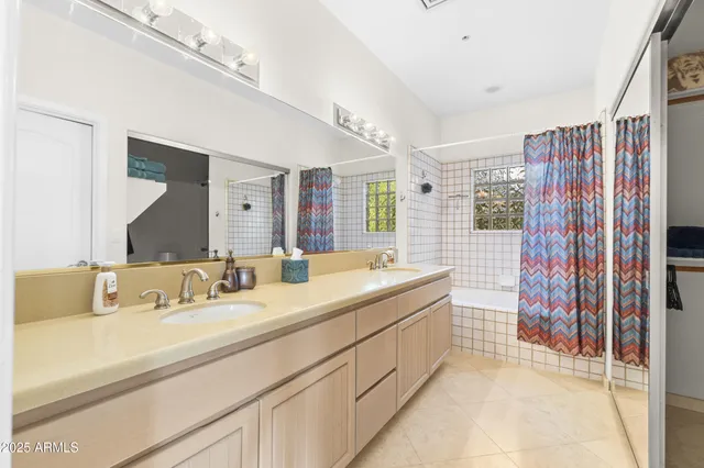 a bathroom with a double vanity sink mirror and shower