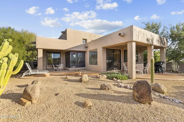 a view of a house with backyard and sitting area
