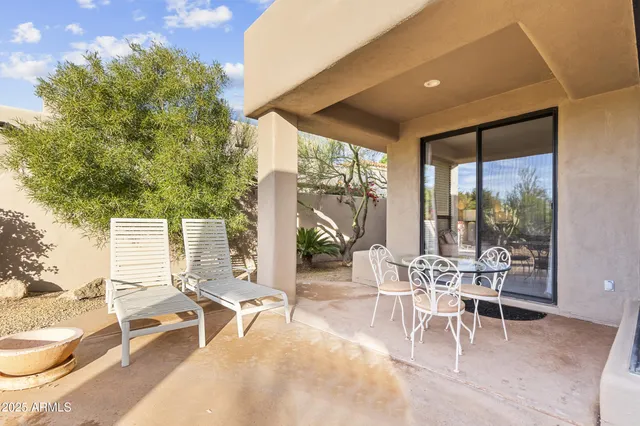 a building outdoor space with patio furniture and potted plants