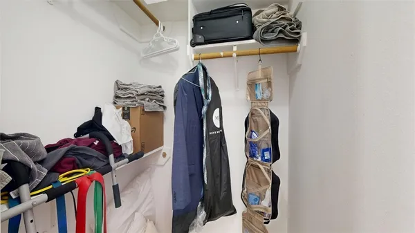 a view of walk in closet with clothes and shoes
