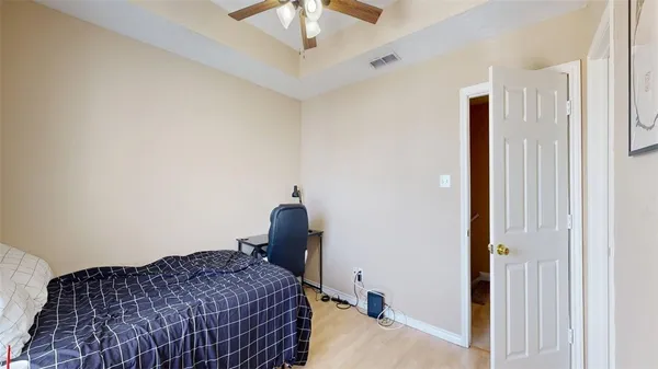 a bedroom with a bed and a chandelier fan