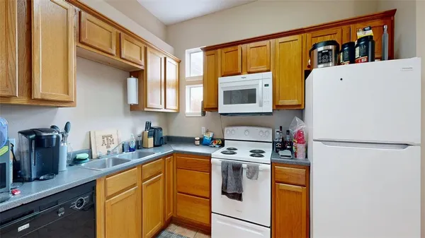 a kitchen with stainless steel appliances a stove a sink cabinets and a refrigerator