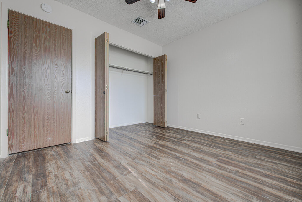 7908 West Gate Boulevard, Unit B Austin, TX 78745 - Photo 16 of 23 Unfurnished bedroom with a textured ceiling, wood finished floors, a ceiling fan, and a closet