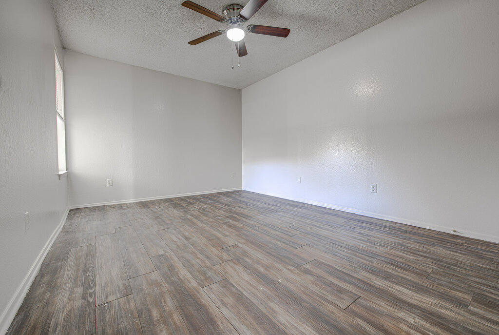 7908 West Gate Boulevard, Unit B Austin, TX 78745 - Photo 18 of 23 Unfurnished room featuring dark wood-style flooring, a textured ceiling, and a ceiling fan