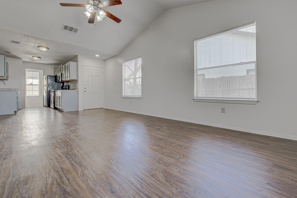 7908 West Gate Boulevard, Unit B Austin, TX 78745 - Photo 7 of 23 Unfurnished living room with dark wood-style floors, a high ceiling, and a ceiling fan
