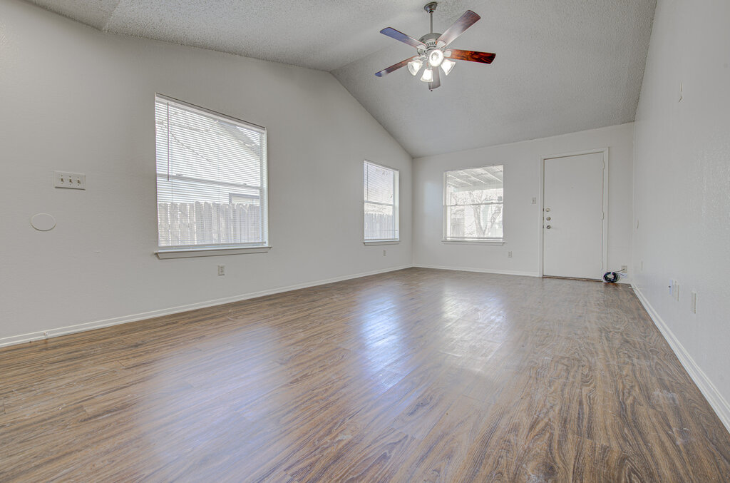 7908 West Gate Boulevard, Unit B Austin, TX 78745 - Photo 9 of 23 Empty room with wood finished floors, ceiling fan, and a textured ceiling