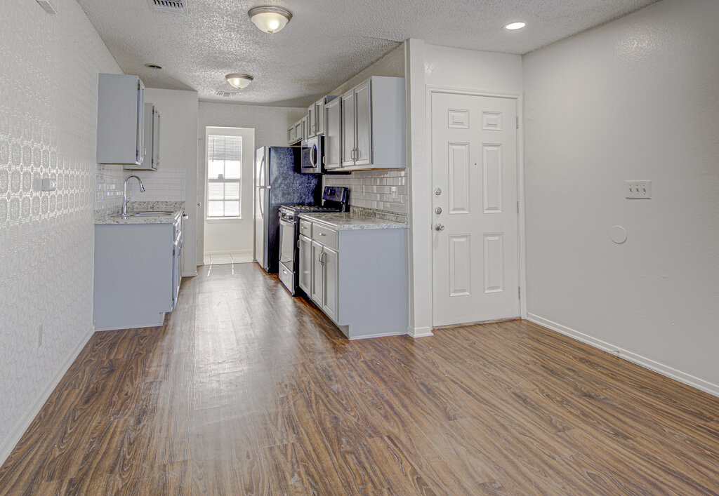 7908 West Gate Boulevard, Unit B Austin, TX 78745 - Photo 10 of 23 Kitchen featuring stainless steel appliances, decorative backsplash, gray cabinetry, and a textured ceiling