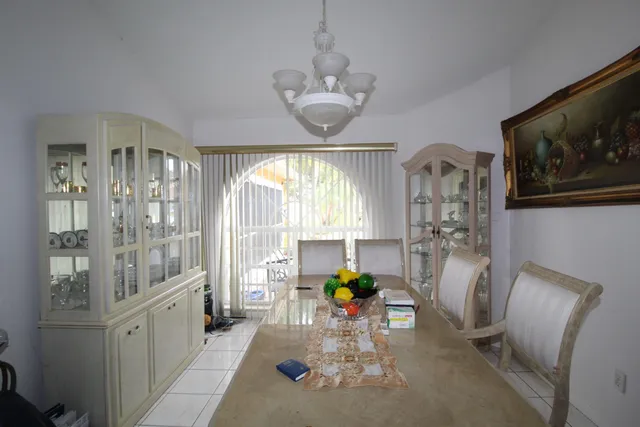 a dining room with furniture a chandelier and wooden floor