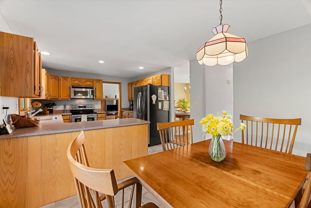 1 Stacey Lane Amesbury, MA 01913 - Photo 12 of 41 a kitchen with stainless steel appliances granite countertop a dining table chairs and granite counter tops