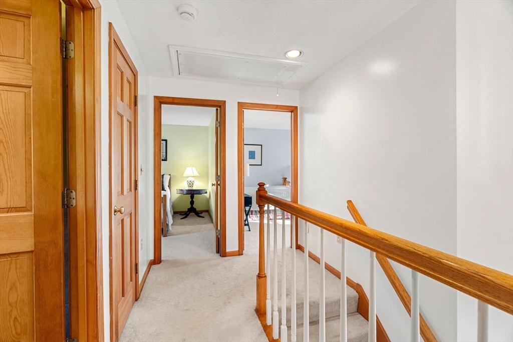 1 Stacey Lane Amesbury, MA 01913 - Photo 22 of 41 a view of a hallway to a livingroom with wooden floor and stairs