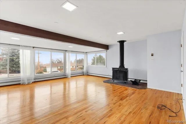 a view of empty room with wooden floor and floor to ceiling window