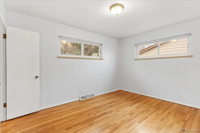 a view of empty room with wooden floor
