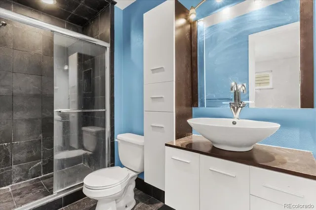 a bathroom with a sink a toilet and shower