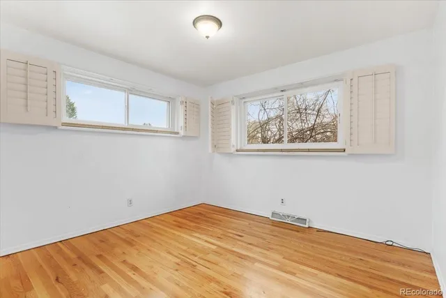 a view of empty room with wooden floor