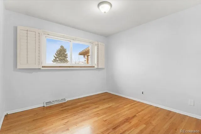 a view of a room with wooden floor and window