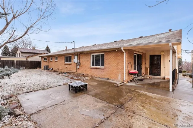 a backyard of a house with table and chairs and barbeque oven