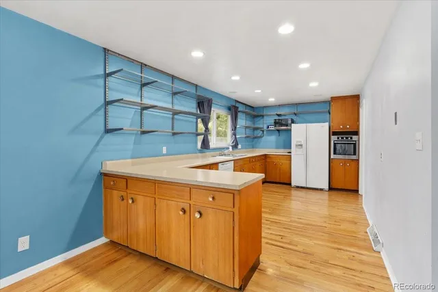 a kitchen with stainless steel appliances granite countertop a sink and a refrigerator