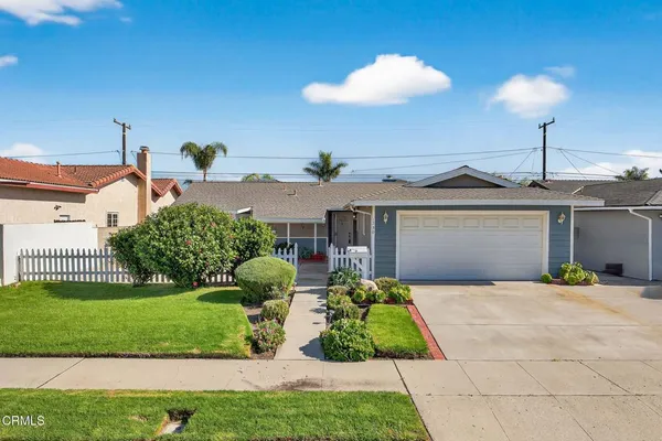 a front view of a house with a yard and potted plants