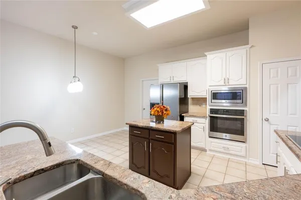 a kitchen with stainless steel appliances a refrigerator and microwave