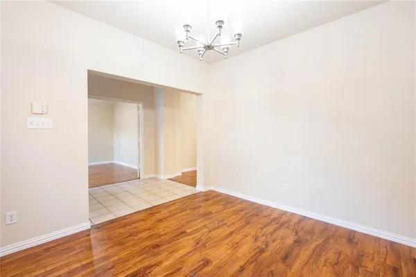 a view of a room with wooden floor and a ceiling fan