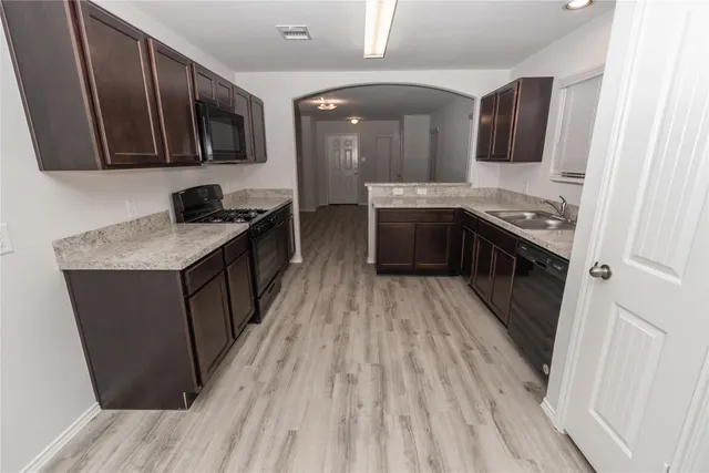 a kitchen with stainless steel appliances granite countertop a stove a sink and a refrigerator