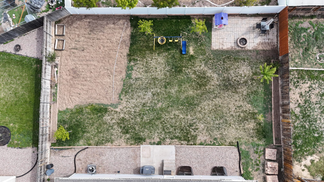 1437 925 South Vernal, UT 84078 - Photo 36 of 47 Expansive backyard featuring a combination of grass and gravel landscaping, a paved patio area, and a fire pit