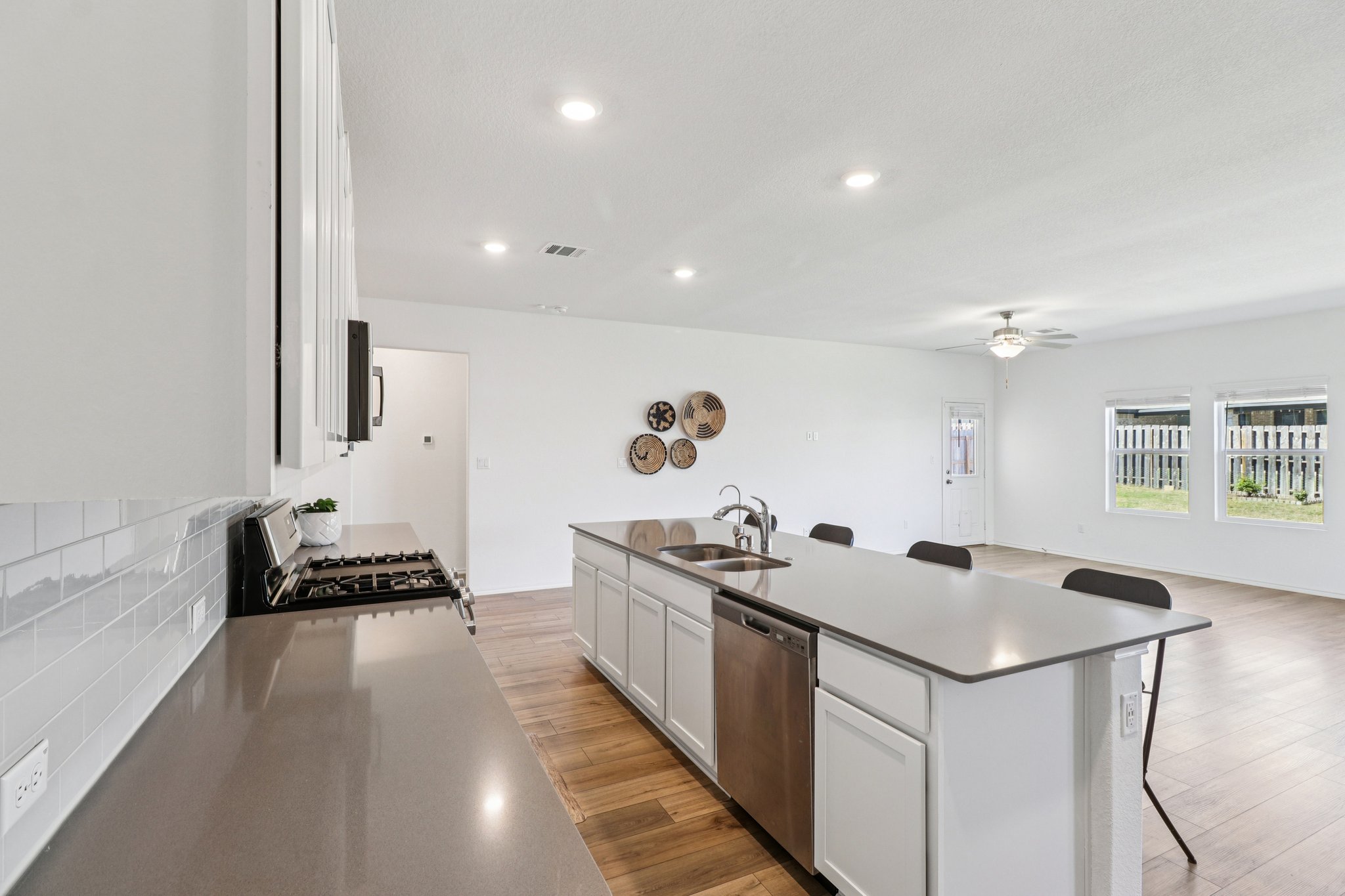 1201 Mallow Road Leander, TX 78641 - Photo 15 of 40 Kitchen featuring a breakfast bar, an island with sink, white cabinetry, stainless steel appliances, and recessed lighting