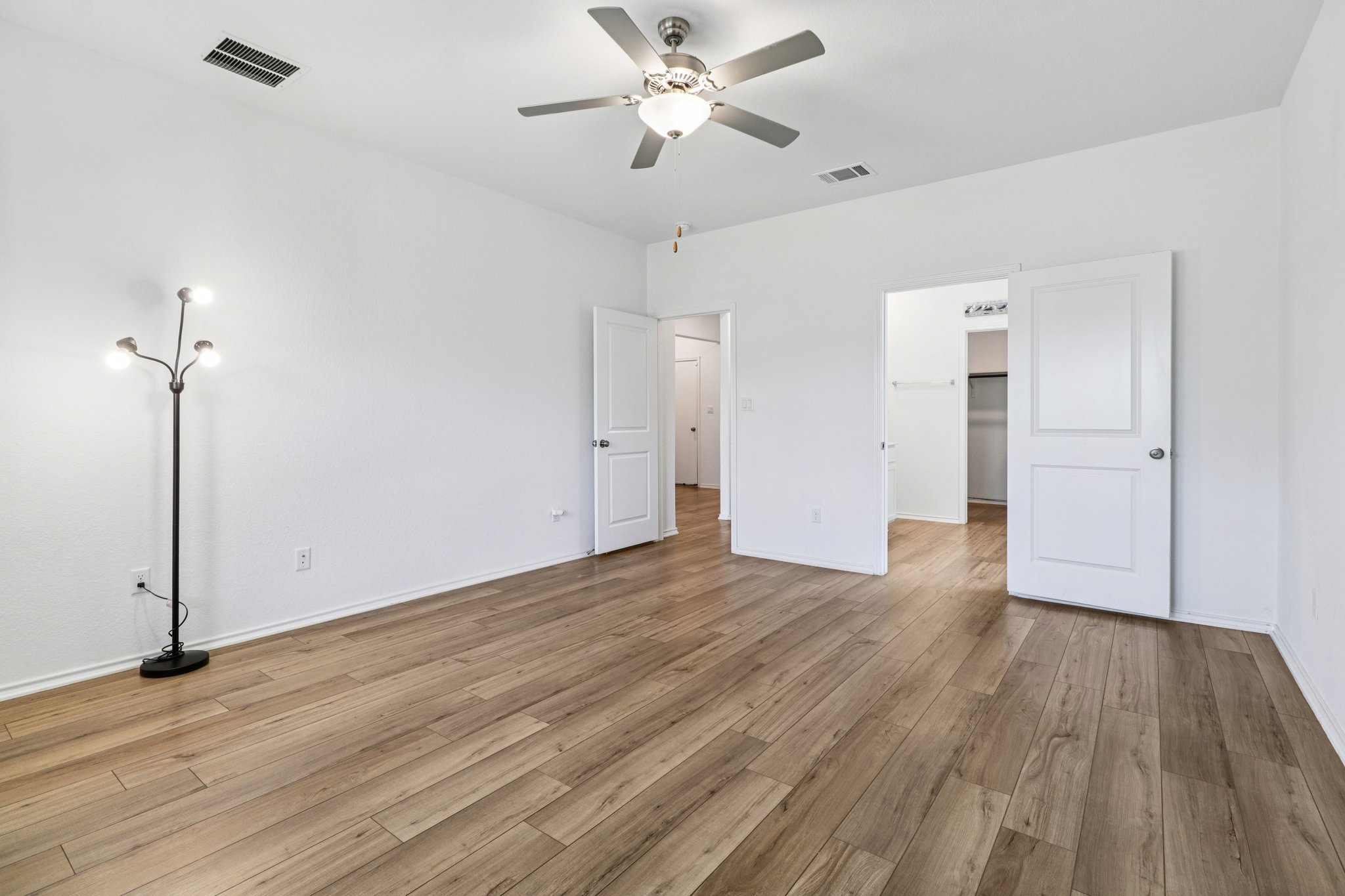 1201 Mallow Road Leander, TX 78641 - Photo 21 of 40 Unfurnished bedroom with a spacious closet, ceiling fan, and light wood-style flooring