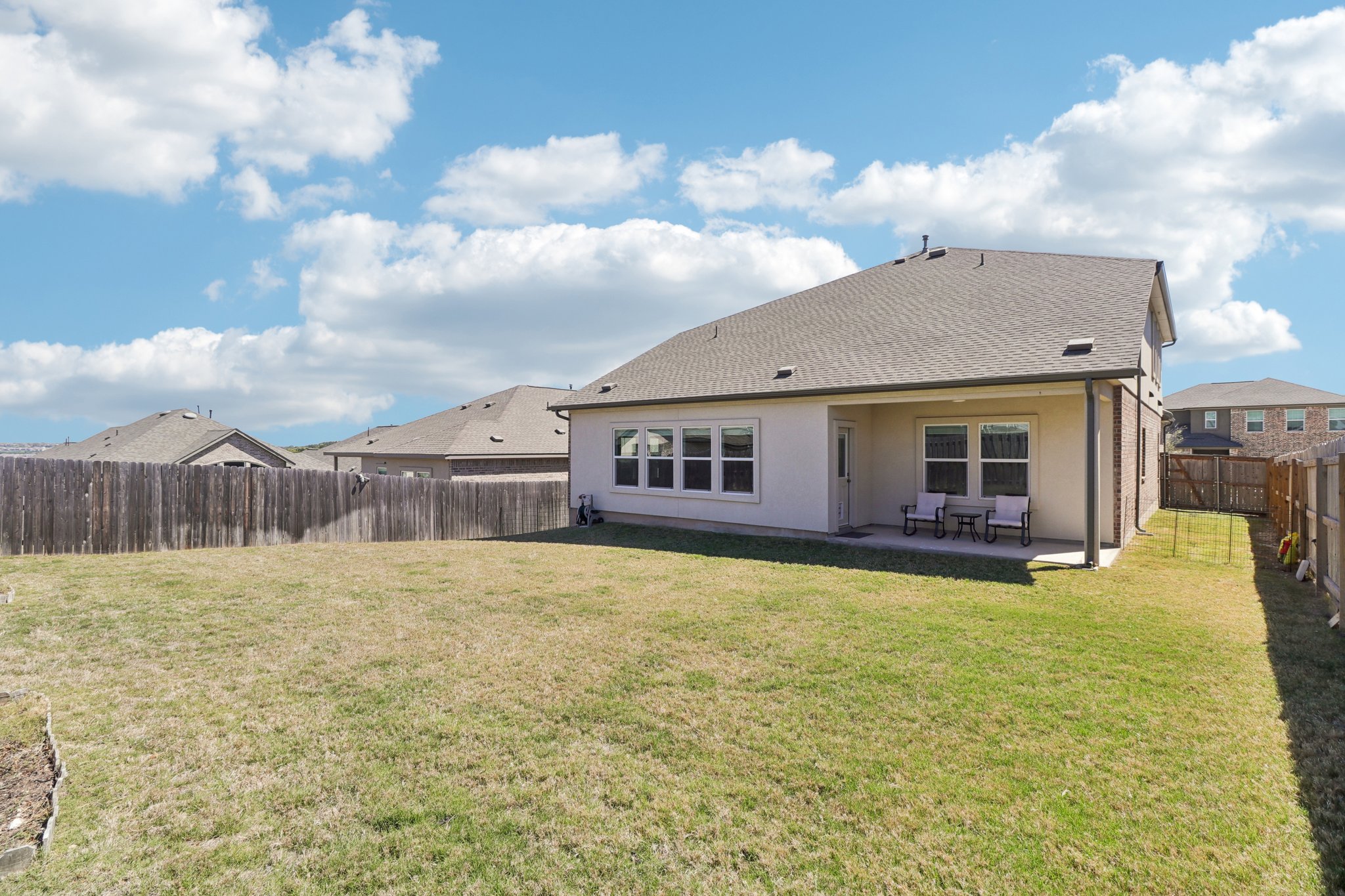 1201 Mallow Road Leander, TX 78641 - Photo 38 of 40 Back of property featuring a fenced backyard, a patio, stucco siding, and roof with shingles