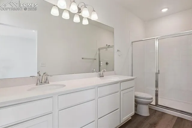 a bathroom with a granite countertop sink a toilet and a mirror