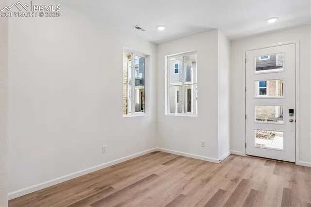 a view of empty room with wooden floor and windows