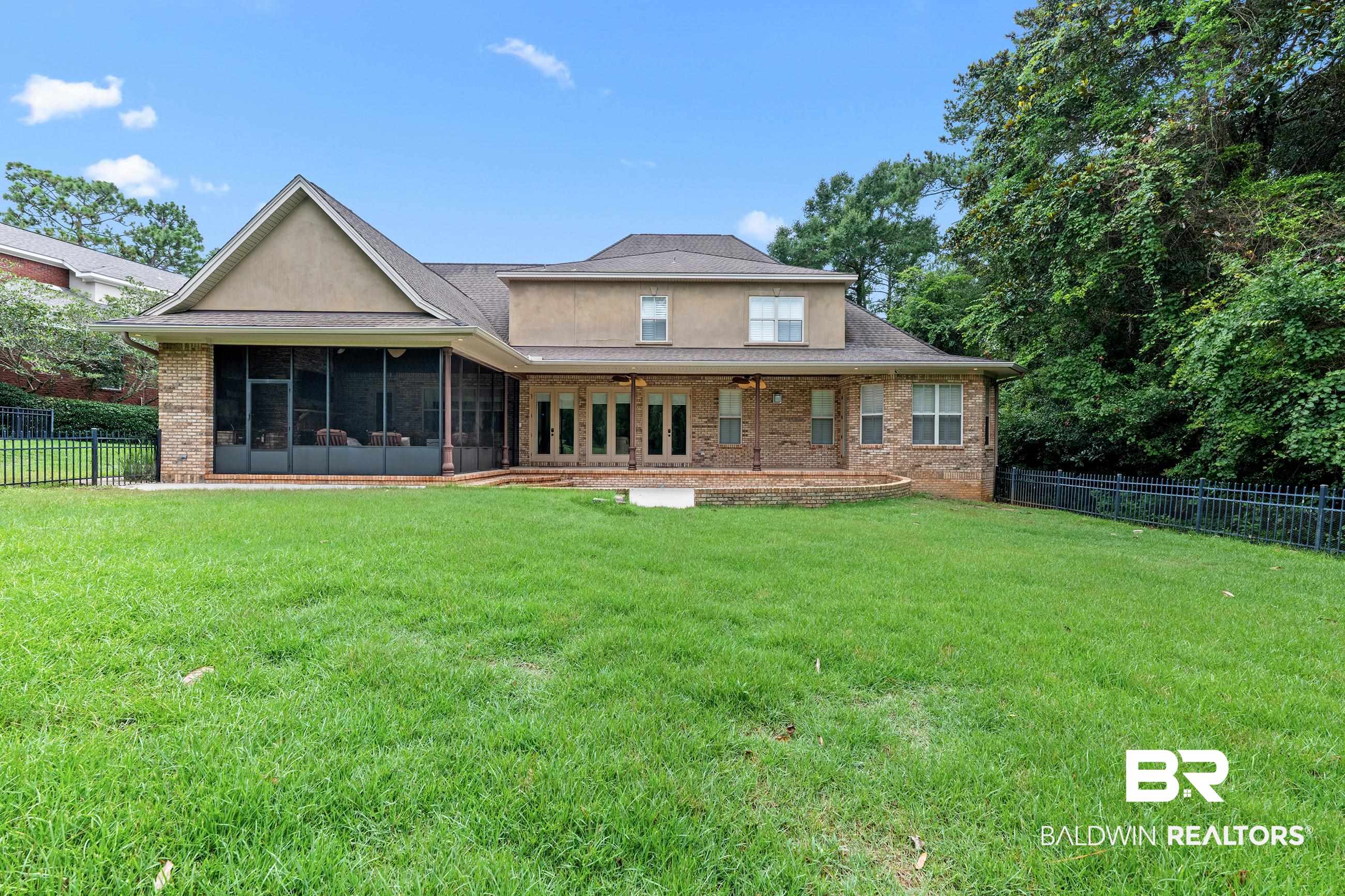 30463 Dolive Ridge Daphne, AL 36527 - Photo 15 of 58 Rear exterior featuring a screened porch, brick patio, and an expansive lawn