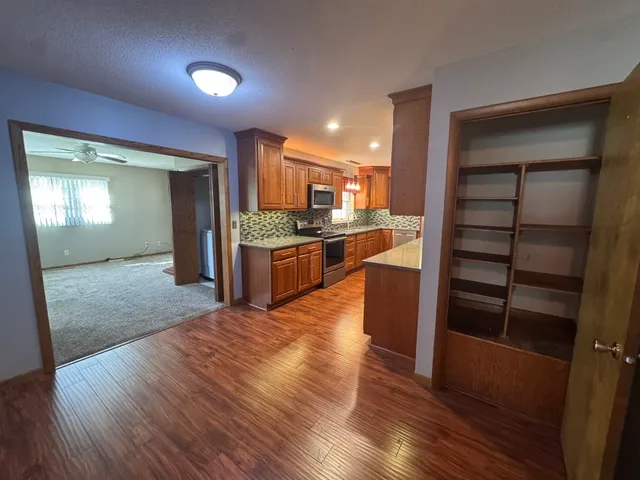 a large kitchen with stainless steel appliances granite countertop a refrigerator and a stove top oven