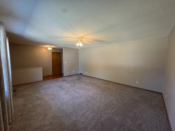 an empty room with windows and fireplace