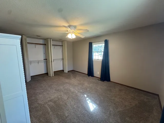 a view of empty room with closet and ceiling fan
