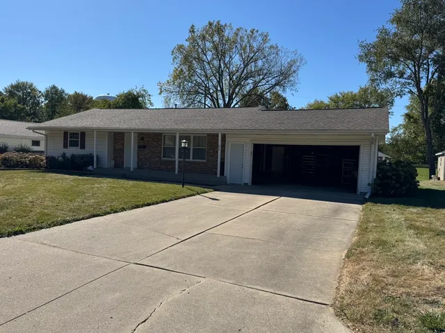 a front view of a house with yard and trees