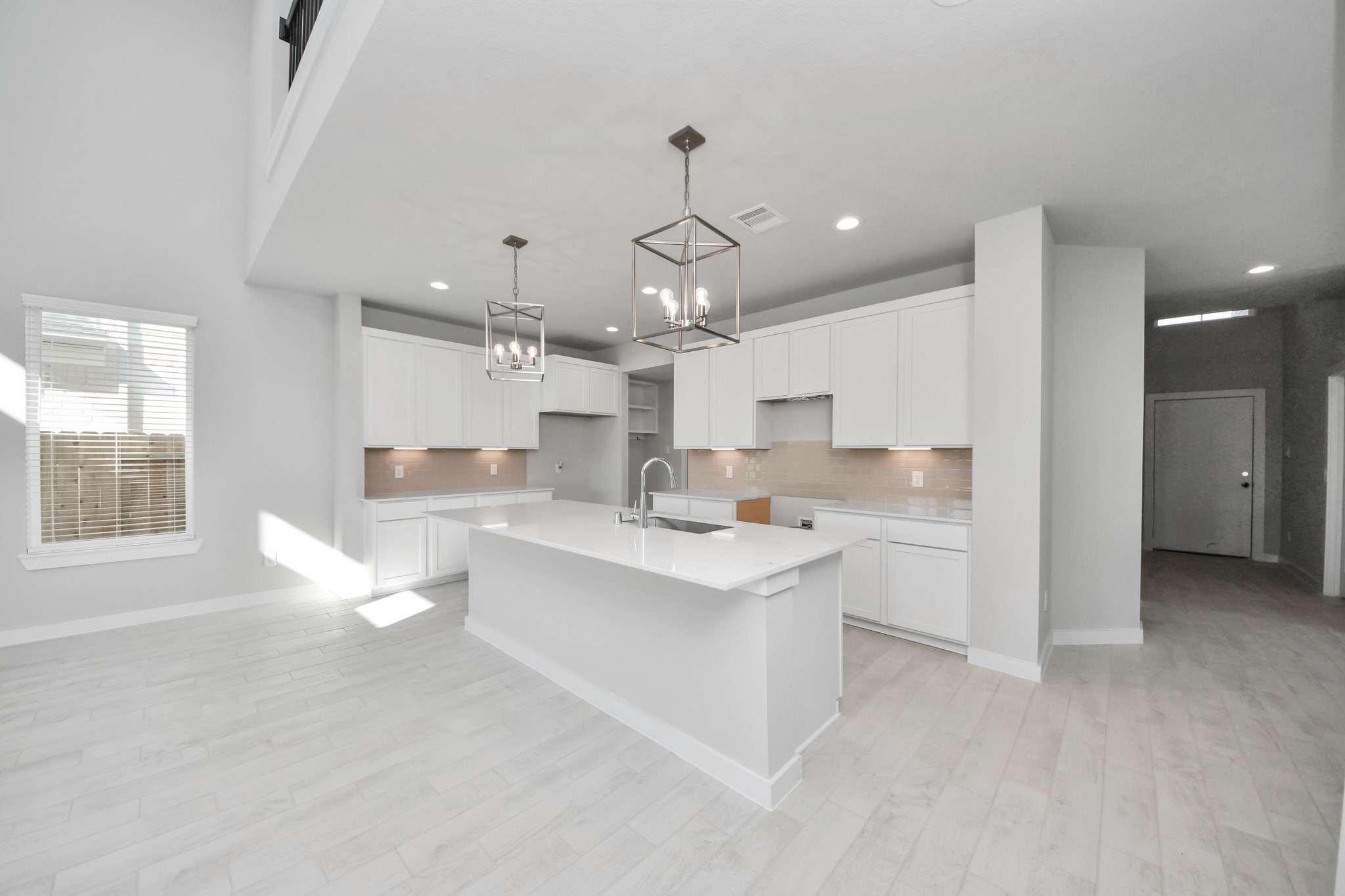 3006 Burris Park Drive Spring, TX 77373 - Photo 14 of 45 Step into a dream realized with this generously spacious kitchen! A massive granite island takes center stage, complemented by high ceilings and soft-close cabinets. The granite countertops, stainless steel appliances, sleek tile backsplash, and recessed lighting complete the elegant design.